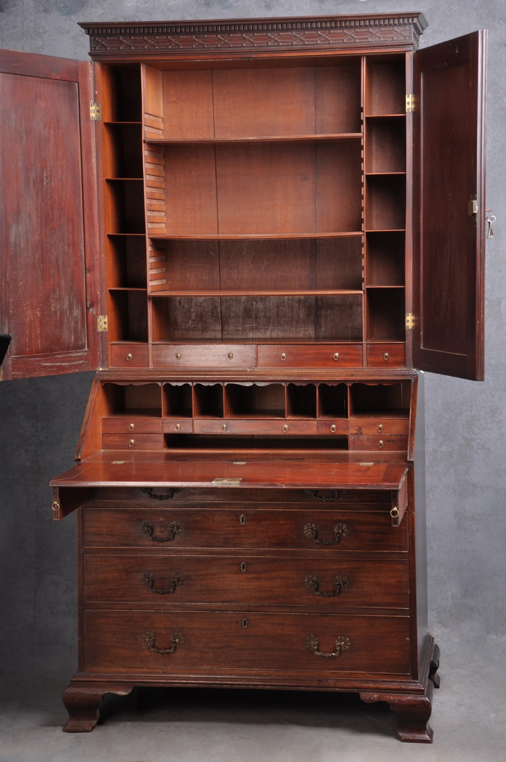 An 18th-century mahogany bureau bookcase featuring a blind two-door upper cabinet, a slant-front writing slope, four long drawers, and bracket feet. View II