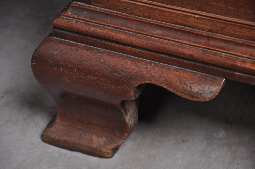 An 18th-century mahogany bureau bookcase featuring a blind two-door upper cabinet, a slant-front writing slope, four long drawers, and bracket feet. View X