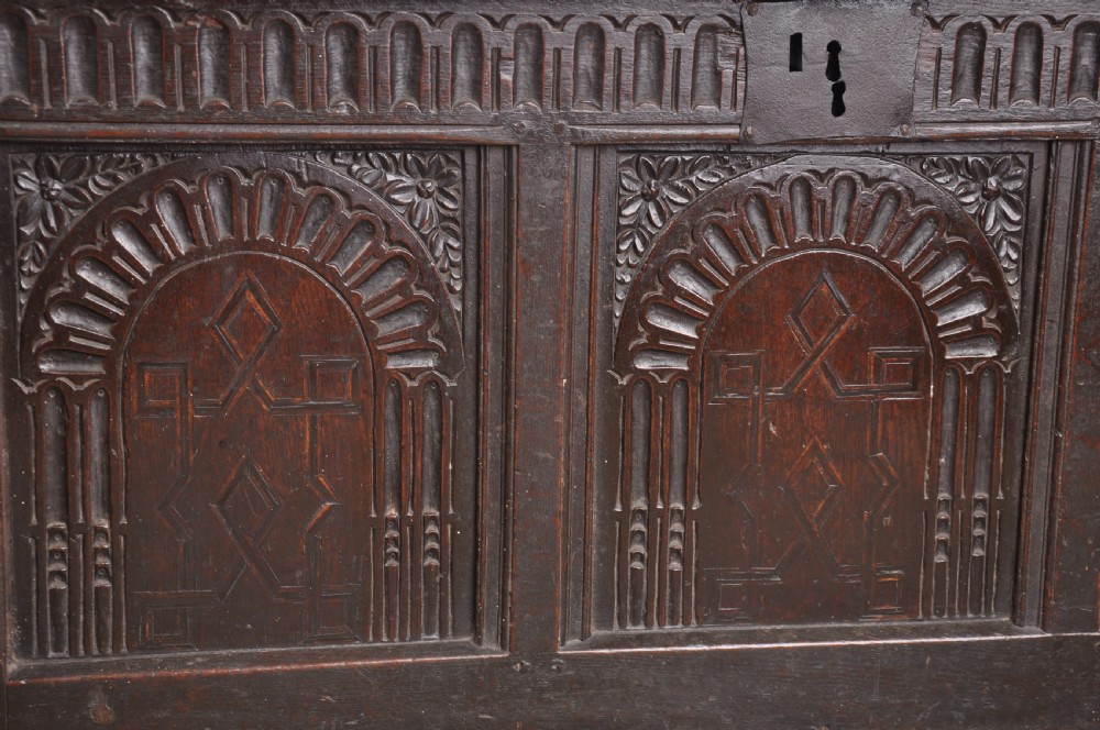 A dark oak three-panel coffer featuring relief-carved arches, geometric strapwork, a carved frieze, and a central iron keyhole plate. View IV