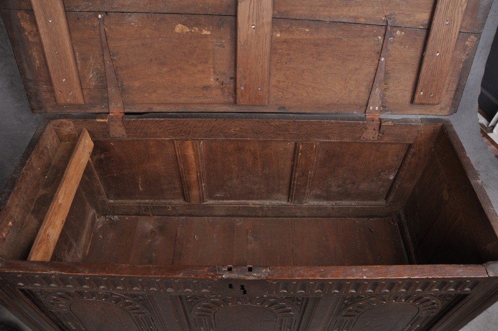 A dark oak three-panel coffer featuring relief-carved arches, geometric strapwork, a carved frieze, and a central iron keyhole plate. View VIII
