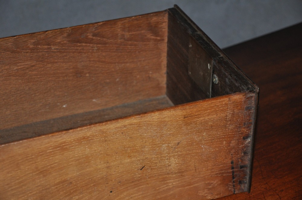 An 18th-century Georgian mahogany kneehole desk featuring six small drawers, one long top drawer, a central recessed cupboard, and brass handles on bracket feet. View IV