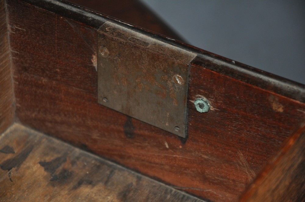 An 18th-century Georgian mahogany kneehole desk featuring six small drawers, one long top drawer, a central recessed cupboard, and brass handles on bracket feet. View V