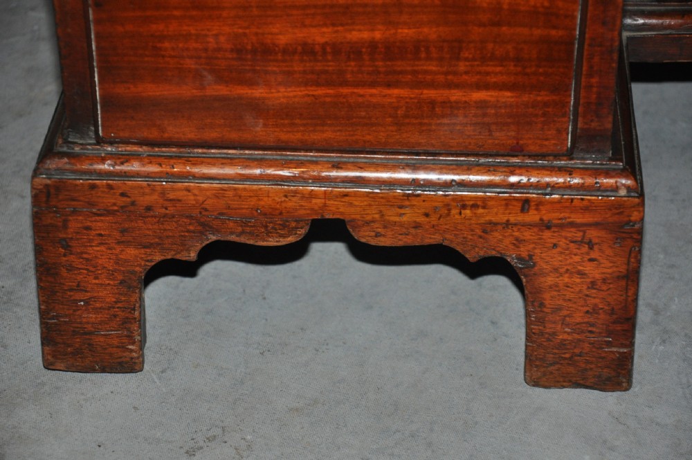 An 18th-century Georgian mahogany kneehole desk featuring six small drawers, one long top drawer, a central recessed cupboard, and brass handles on bracket feet. View XII