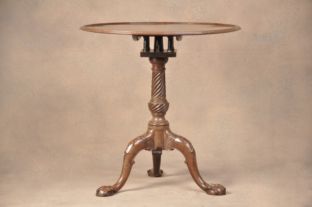 An 18th-century mahogany tilt-top tripod table shown with its circular surface locked vertically, revealing a spiral-carved pedestal and cabriole legs ending in claw and ball feet. View II