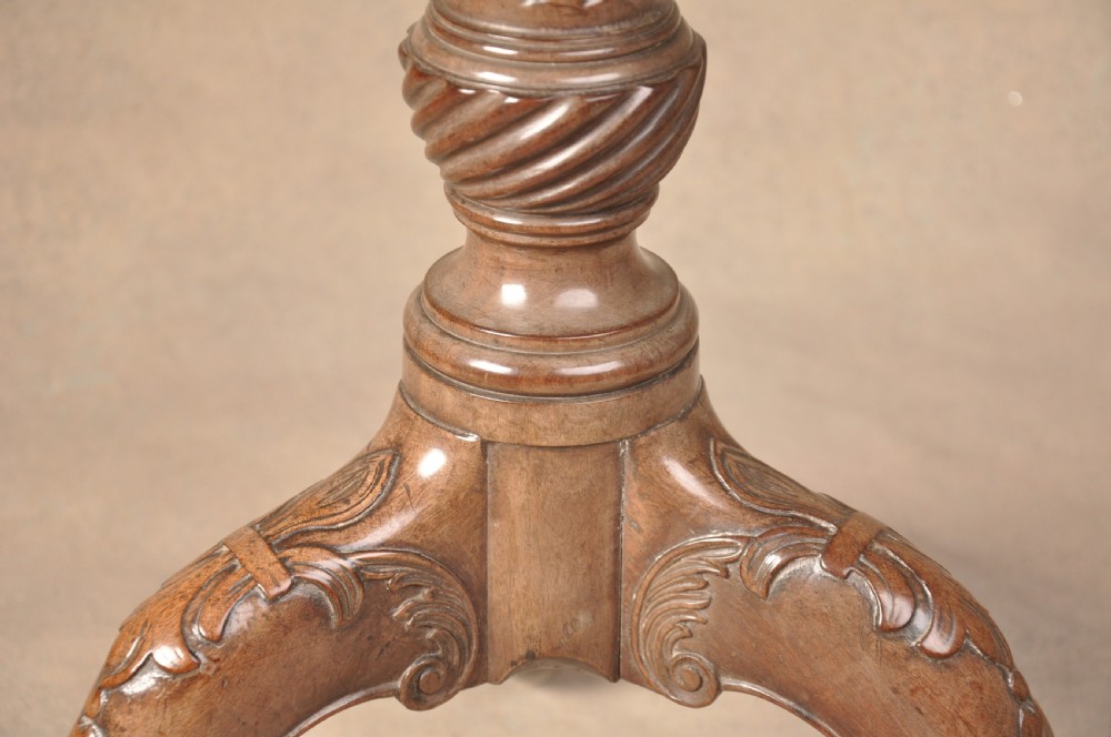 An 18th-century mahogany tilt-top tripod table shown with its circular surface locked vertically, revealing a spiral-carved pedestal and cabriole legs ending in claw and ball feet. View IV