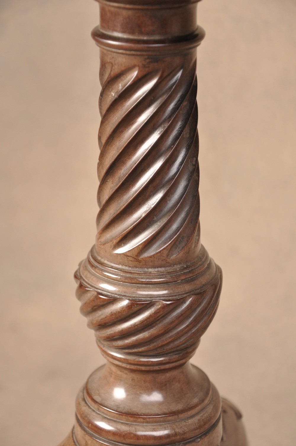 An 18th-century mahogany tilt-top tripod table shown with its circular surface locked vertically, revealing a spiral-carved pedestal and cabriole legs ending in claw and ball feet. View V