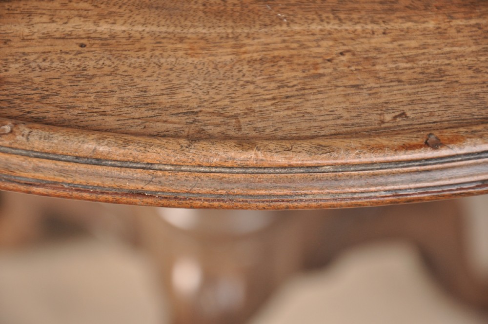 An 18th-century mahogany tilt-top tripod table shown with its circular surface locked vertically, revealing a spiral-carved pedestal and cabriole legs ending in claw and ball feet. View IX