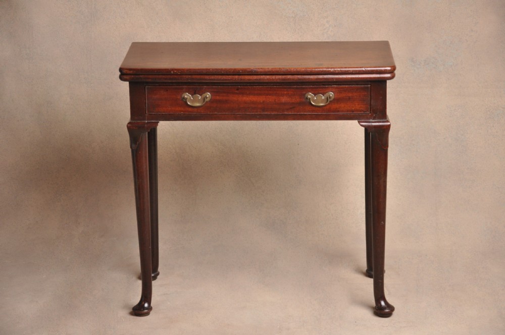 A mid-18th-century mahogany fold-over tea table featuring a single frieze drawer with brass handles and slender cabriole legs ending in pad feet. View II