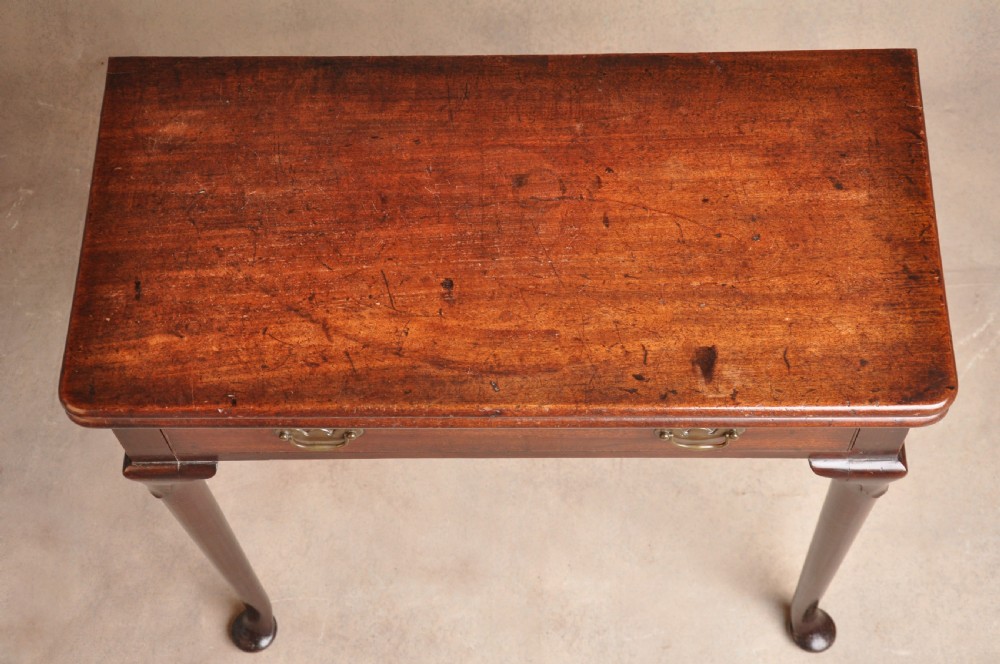 A mid-18th-century mahogany fold-over tea table featuring a single frieze drawer with brass handles and slender cabriole legs ending in pad feet. View IV