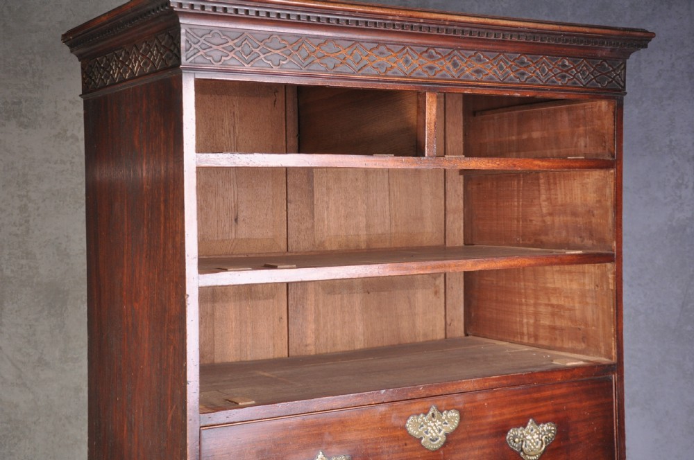 An 18th-century mahogany tallboy featuring two sections of graduated drawers, brass handles, carved blind fretwork frieze, and ogee bracket feet. View VIII