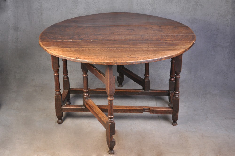 A seventeenth-century oak gateleg table shown with drop leaves folded down, featuring turned legs and low box stretchers. View II