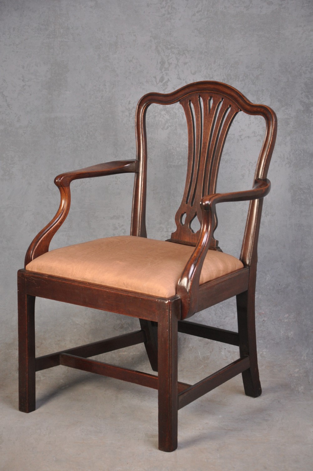 An 18th-century Hepplewhite style mahogany armchair featuring a carved pierced splat, shaped arms, square legs with stretchers, and a beige upholstered seat. View II