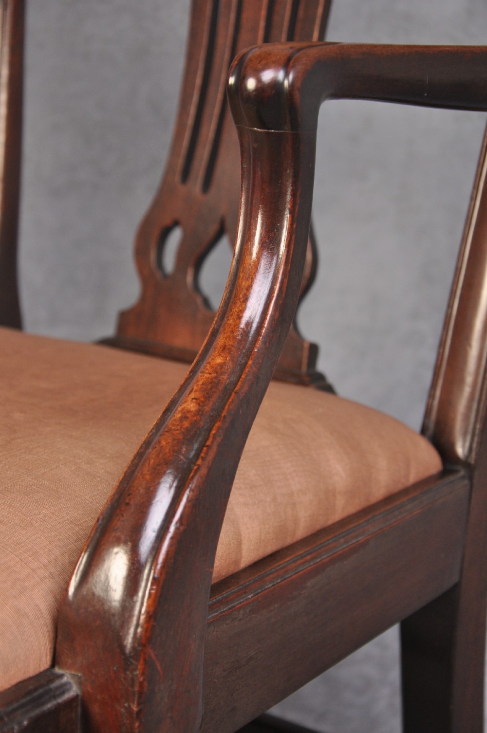An 18th-century Hepplewhite style mahogany armchair featuring a carved pierced splat, shaped arms, square legs with stretchers, and a beige upholstered seat. View IV