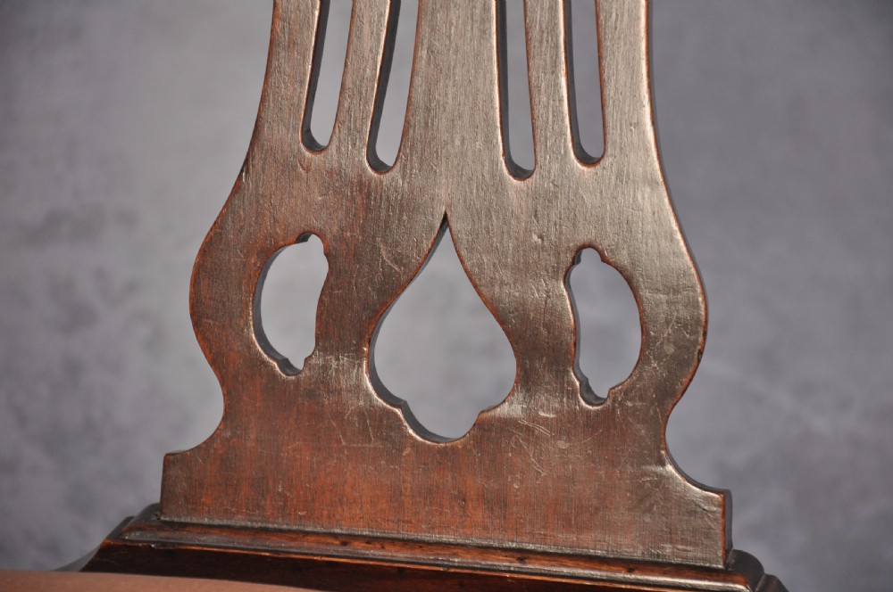 An 18th-century Hepplewhite style mahogany armchair featuring a carved pierced splat, shaped arms, square legs with stretchers, and a beige upholstered seat. View VI