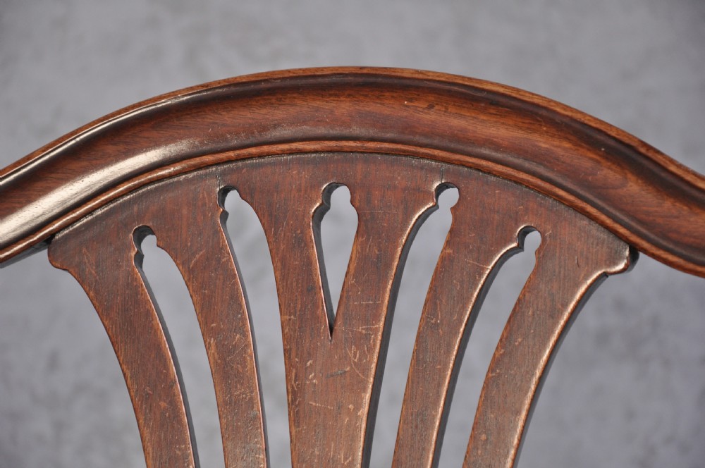 An 18th-century Hepplewhite style mahogany armchair featuring a carved pierced splat, shaped arms, square legs with stretchers, and a beige upholstered seat. View VII