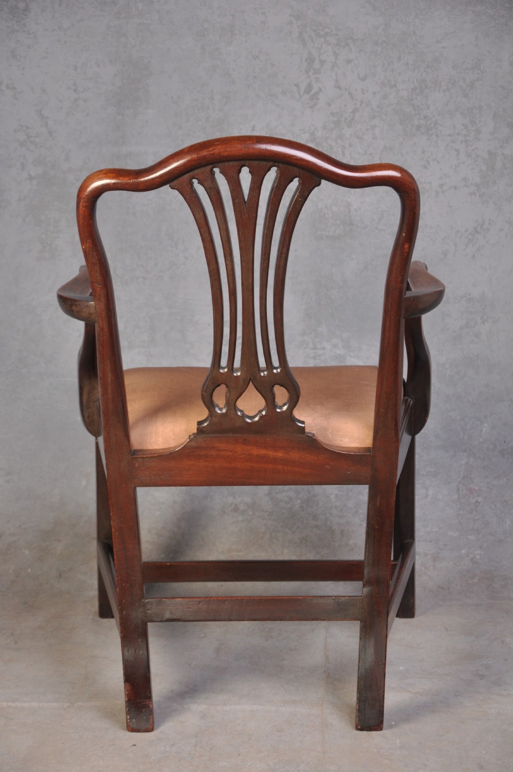 An 18th-century Hepplewhite style mahogany armchair featuring a carved pierced splat, shaped arms, square legs with stretchers, and a beige upholstered seat. View VIII
