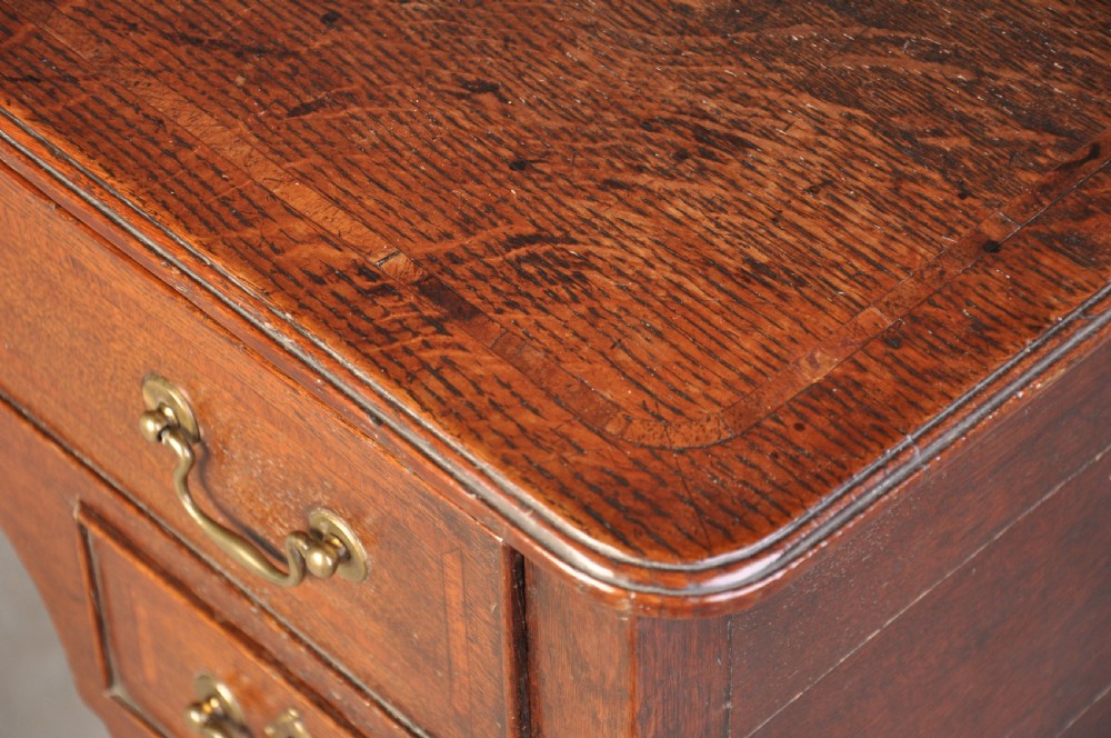An 18th-century oak lowboy table featuring three inlaid drawers, brass swan-neck handles, an arched apron, and cabriole legs. View II