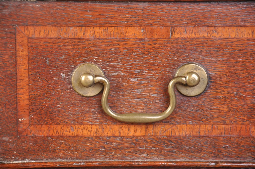 An 18th-century oak lowboy table featuring three inlaid drawers, brass swan-neck handles, an arched apron, and cabriole legs. View III