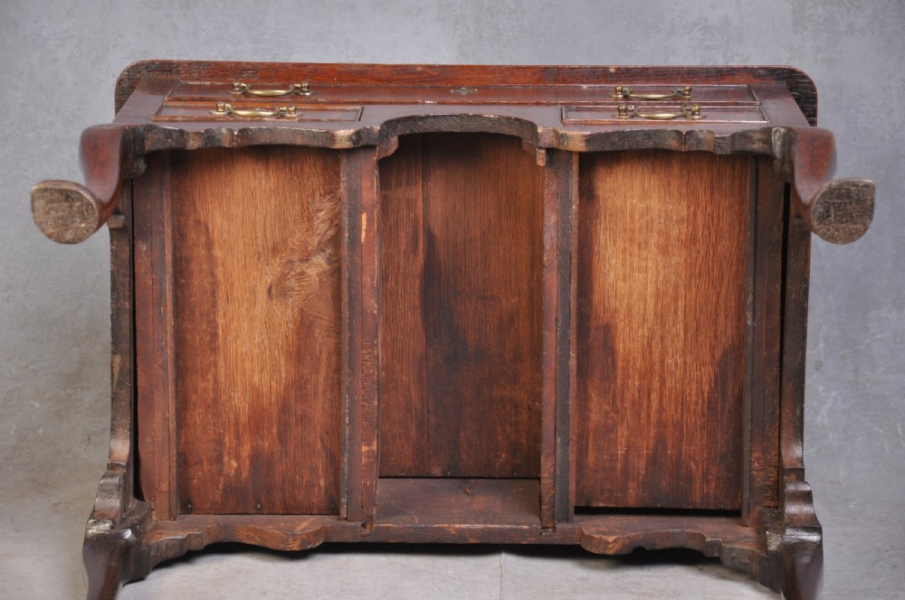 An 18th-century oak lowboy table featuring three inlaid drawers, brass swan-neck handles, an arched apron, and cabriole legs. View X