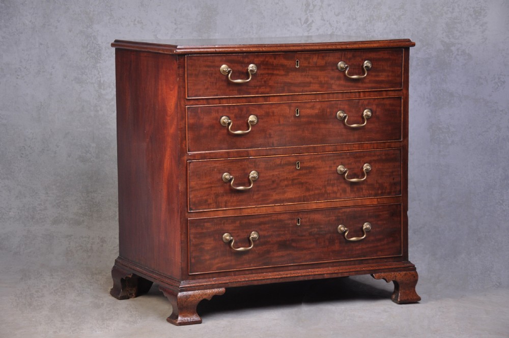 An 18th-century mahogany dressing chest featuring four graduated drawers with brass swan-neck handles and bracket feet.