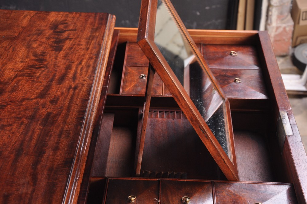 An 18th-century mahogany dressing chest featuring four graduated drawers with brass swan-neck handles and bracket feet. View V