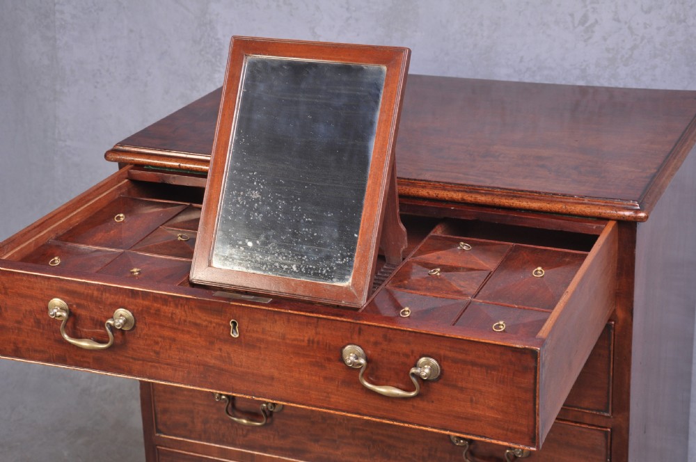 An 18th-century mahogany dressing chest featuring four graduated drawers with brass swan-neck handles and bracket feet. View VI