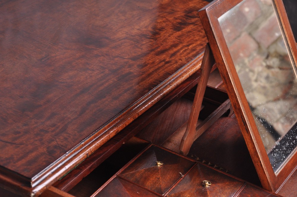 An 18th-century mahogany dressing chest featuring four graduated drawers with brass swan-neck handles and bracket feet. View VII