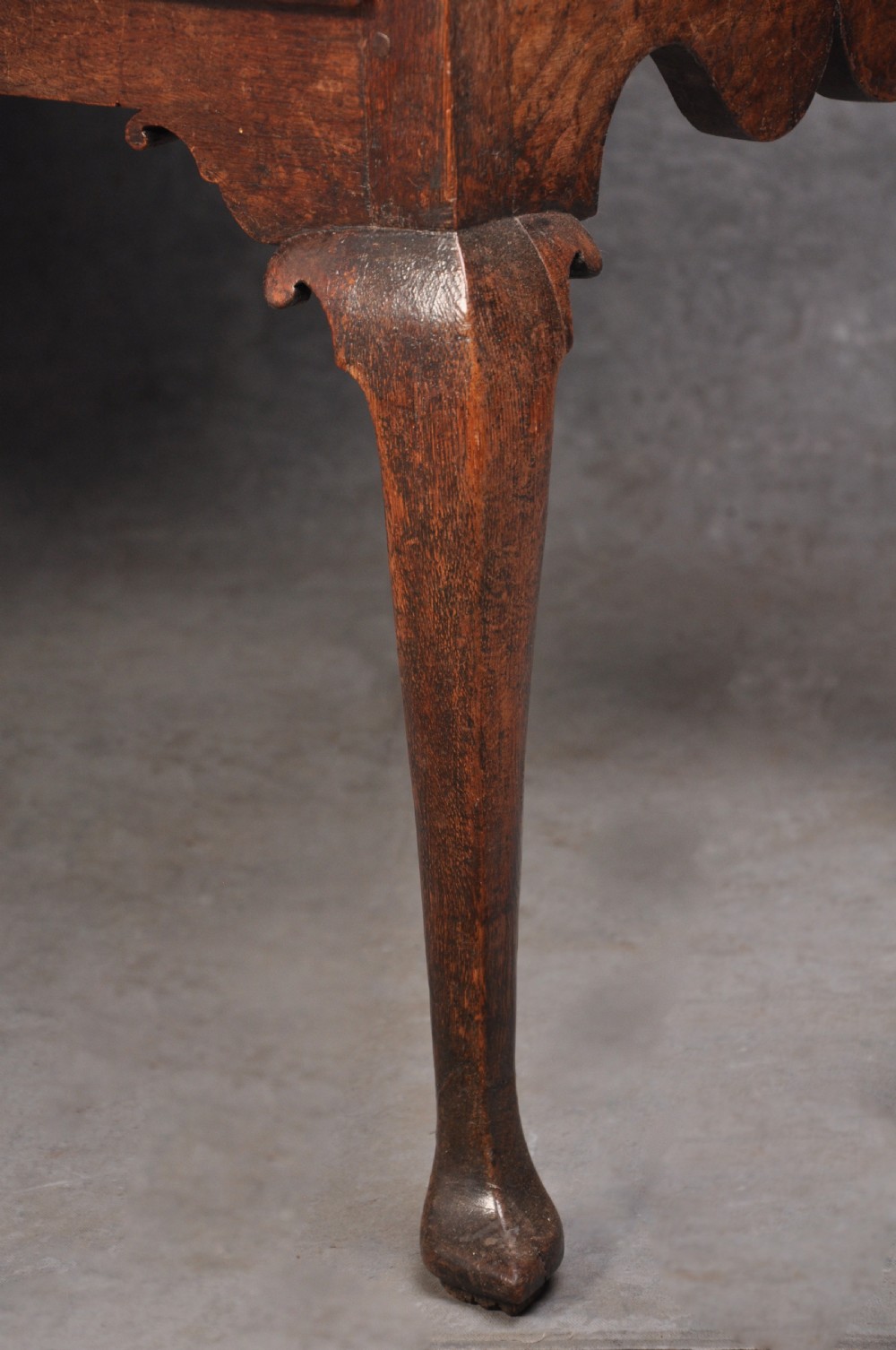 An early 18th-century oak chest on stand featuring two-part construction, multiple drawers with brass drop handles, a shaped apron, and slender cabriole legs. View III