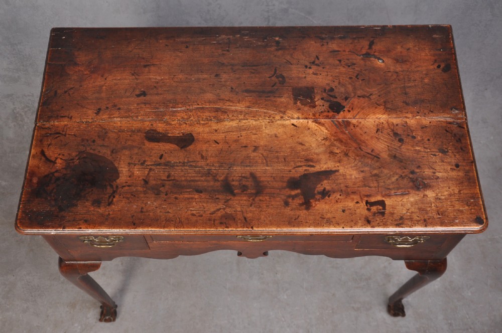 An 18th-century cherrywood lowboy featuring three drawers with brass batwing handles, a shaped apron, and cabriole legs with ball-and-claw feet. View IX