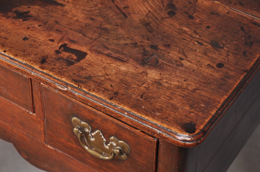 An 18th-century cherrywood lowboy featuring three drawers with brass batwing handles, a shaped apron, and cabriole legs with ball-and-claw feet. View XIII