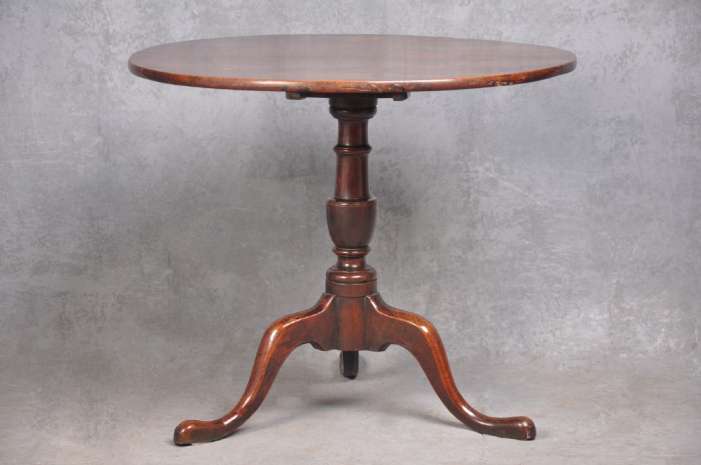 An 18th-century cherrywood tripod table featuring a circular tilt top shown upright, supported by a turned central column and three cabriole legs with pad feet. View II