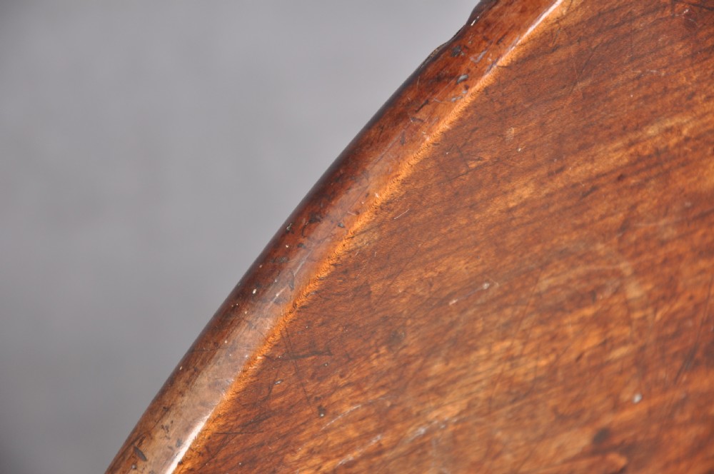An 18th-century cherrywood tripod table featuring a circular tilt top shown upright, supported by a turned central column and three cabriole legs with pad feet. View VI