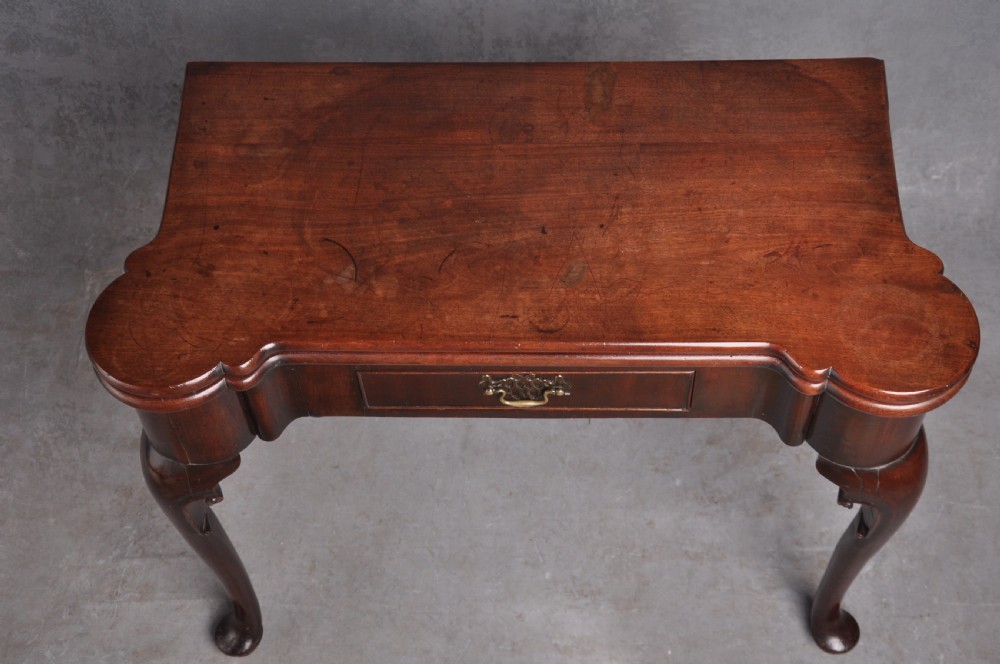 An 18th-century mahogany fold-over card table featuring slender cabriole legs, pad feet, a central drawer with a brass swing handle, and shaped corners. View II
