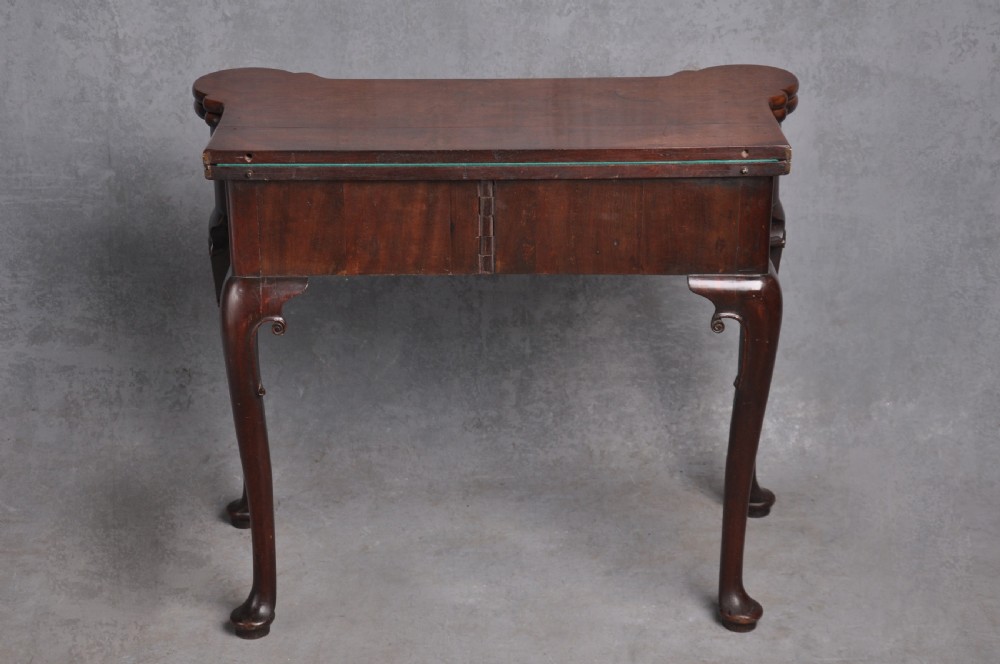 An 18th-century mahogany fold-over card table featuring slender cabriole legs, pad feet, a central drawer with a brass swing handle, and shaped corners. View XI