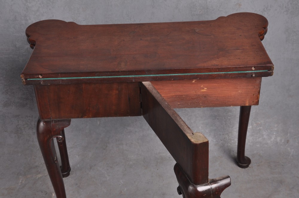 An 18th-century mahogany fold-over card table featuring slender cabriole legs, pad feet, a central drawer with a brass swing handle, and shaped corners. View XII