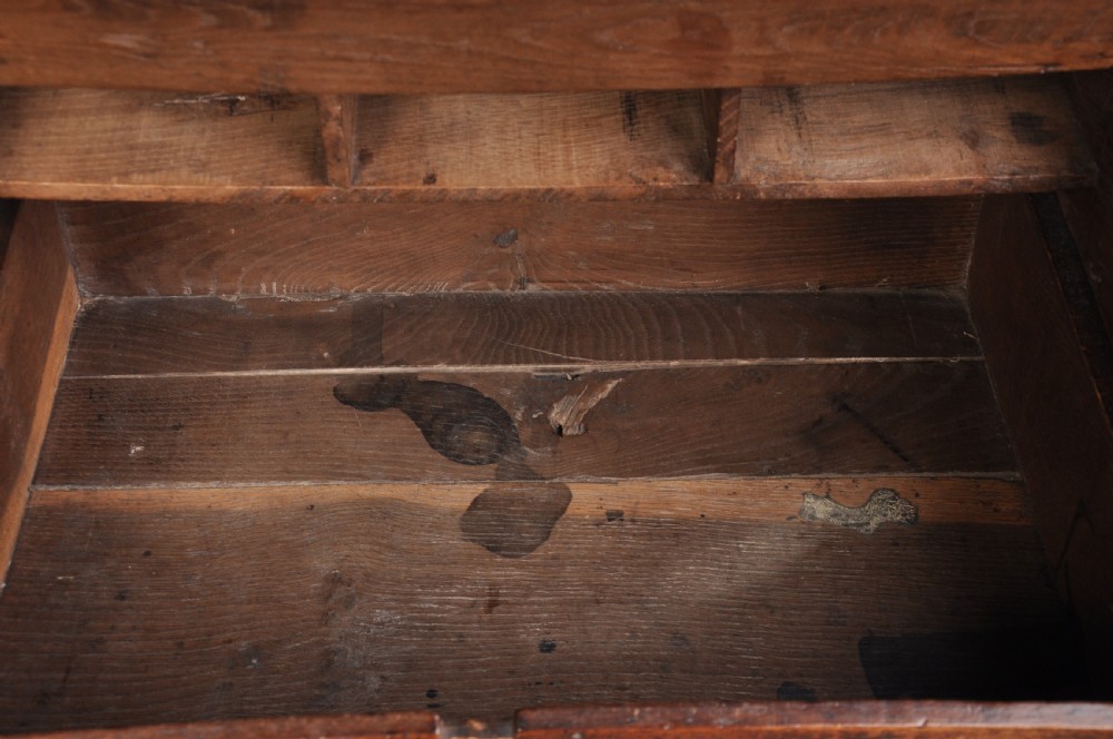 A 17th-century carved oak desk box featuring a sloped writing lid, iron hinges, iron lock plate, and hand-carved scroll motifs across the front panel. View IV