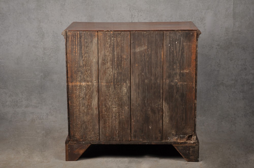 An 18th-century dark oak chest of drawers featuring inlaid drawer borders, pierced brass handles, keyhole escutcheons, and bracket feet. View XI