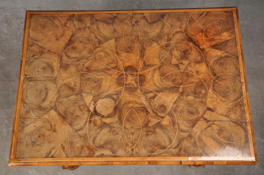 An antique olive wood side table featuring geometric oyster veneering on top, a single drawer with a brass drop handle, four barley twist legs, and a curved stretcher base. View III