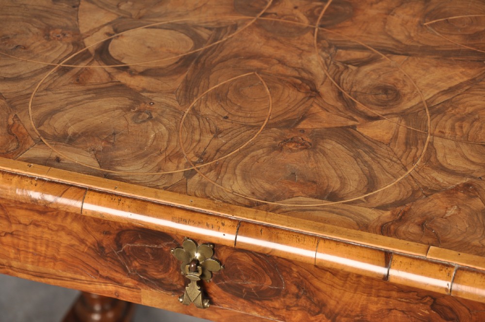 An antique olive wood side table featuring geometric oyster veneering on top, a single drawer with a brass drop handle, four barley twist legs, and a curved stretcher base. View V