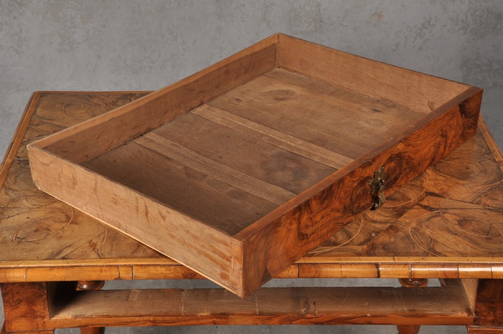 An antique olive wood side table featuring geometric oyster veneering on top, a single drawer with a brass drop handle, four barley twist legs, and a curved stretcher base. View VII