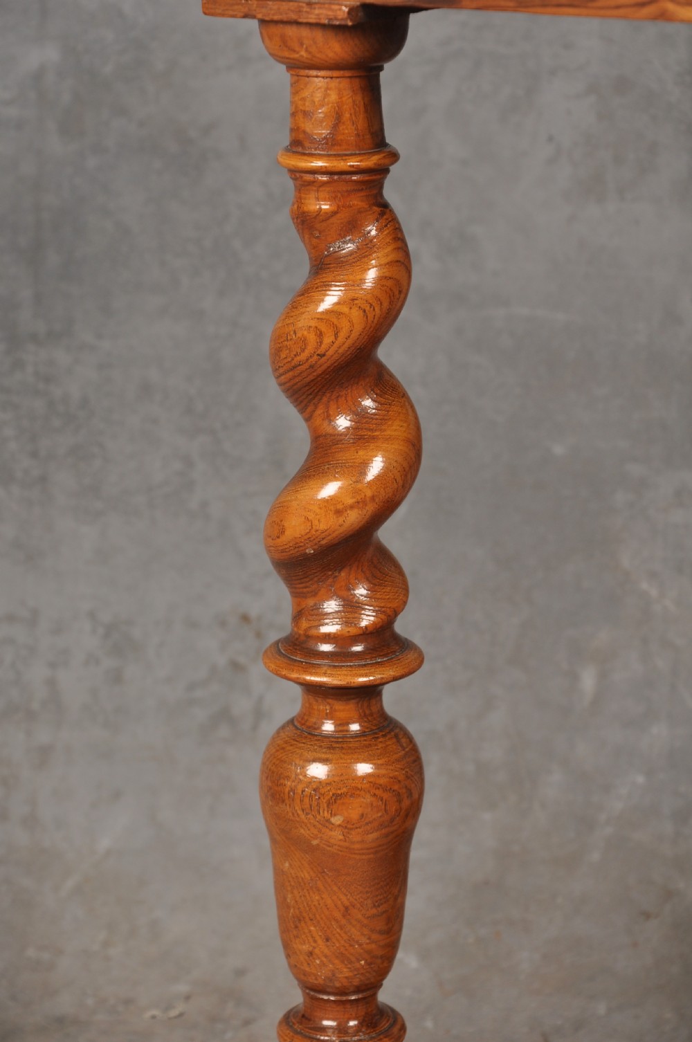 An antique olive wood side table featuring geometric oyster veneering on top, a single drawer with a brass drop handle, four barley twist legs, and a curved stretcher base. View VIII