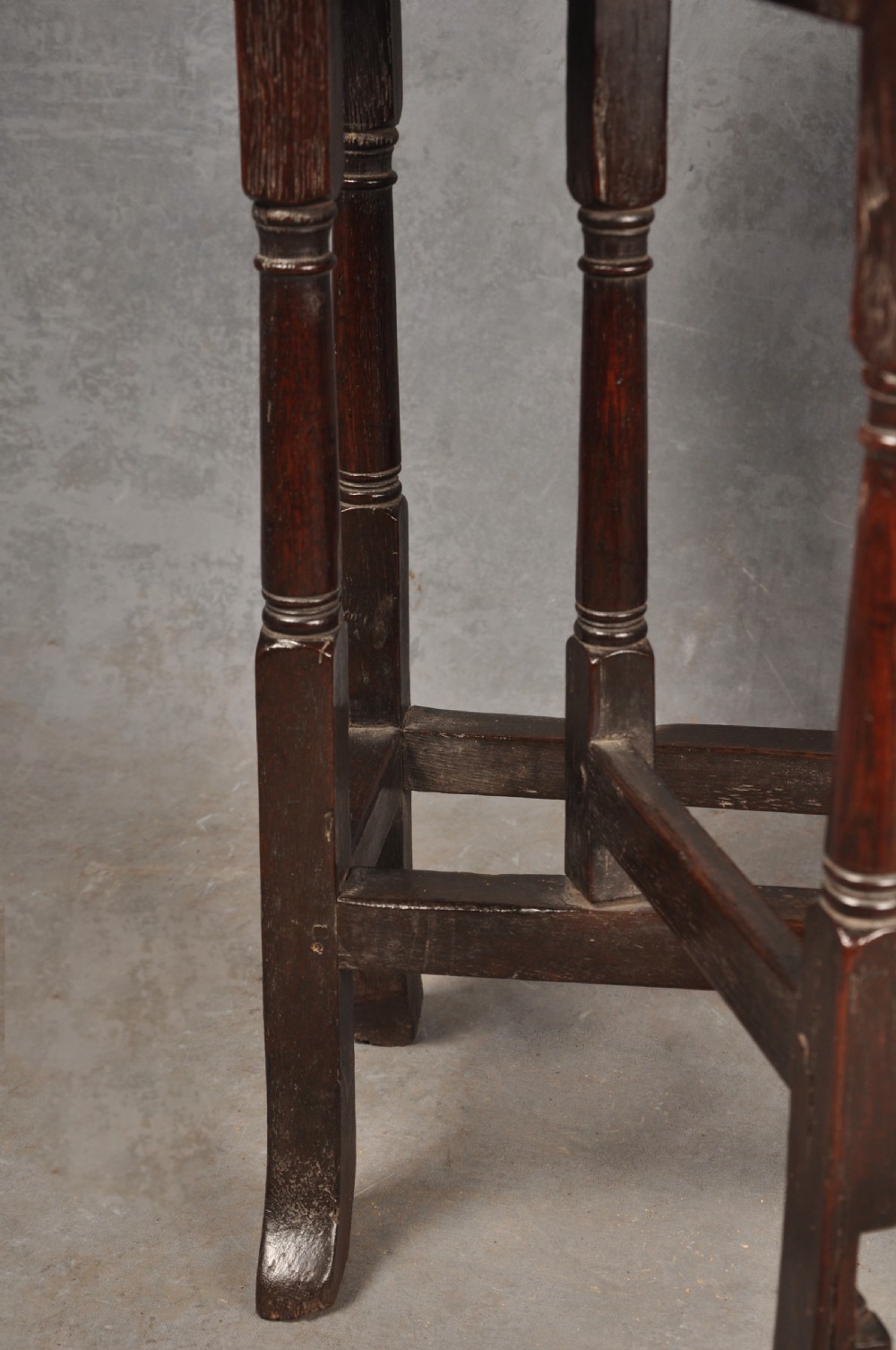 A small dark brown Queen Anne oak gateleg table shown with both drop leaves lowered, featuring turned legs and a stretcher base. View IV