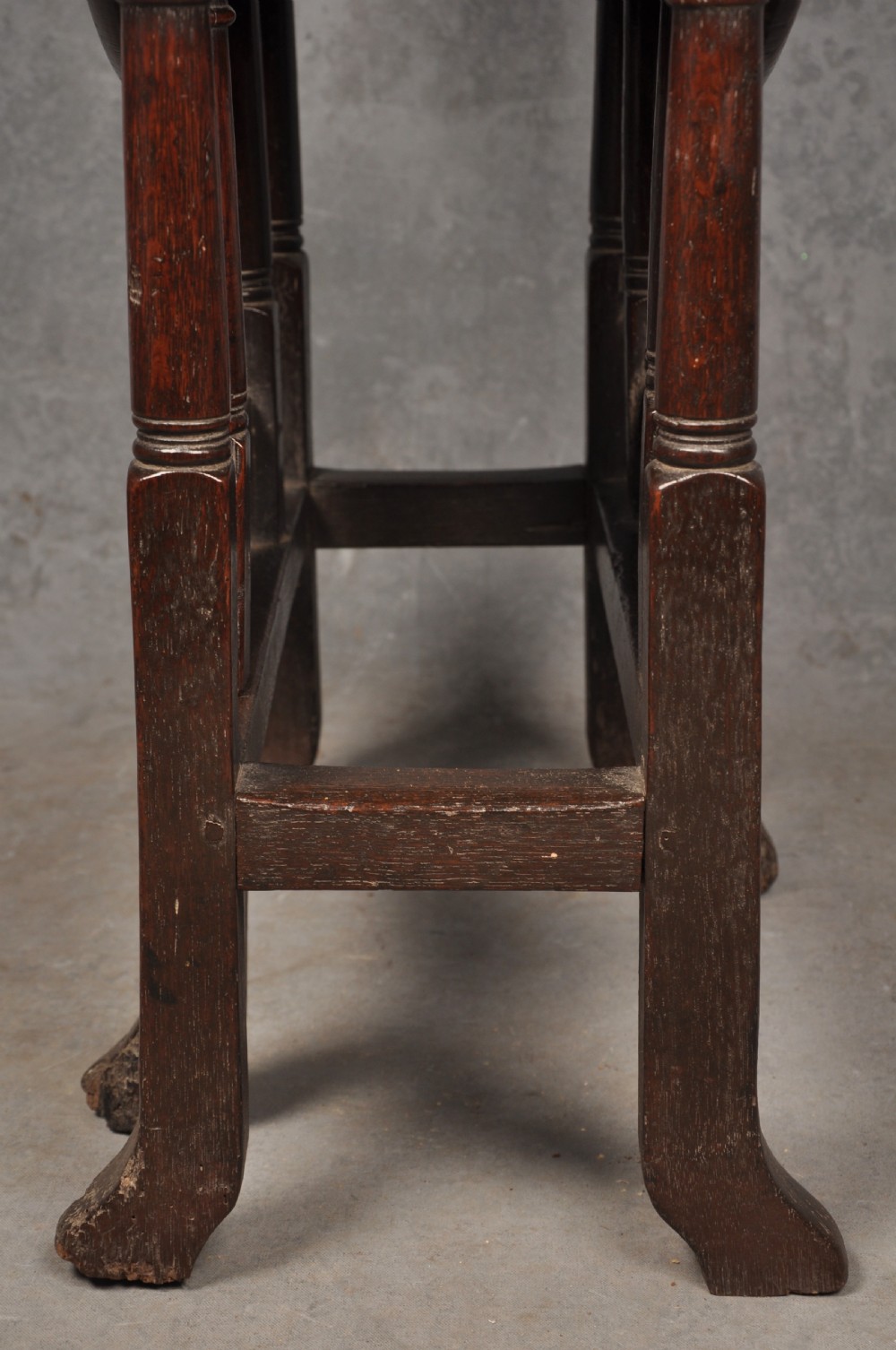 A small dark brown Queen Anne oak gateleg table shown with both drop leaves lowered, featuring turned legs and a stretcher base. View VIII
