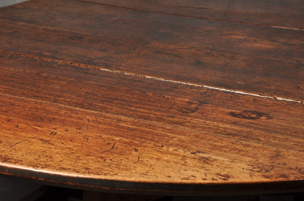 A large 17th-century solid oak gateleg dining table with two drop leaves, turned legs, and square box stretchers. View IX