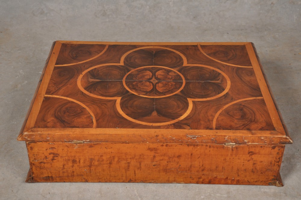 A rectangular 17th-century olive wood lace box featuring geometric oyster veneer marquetry on the lid and a brass keyhole escutcheon on the front. View V
