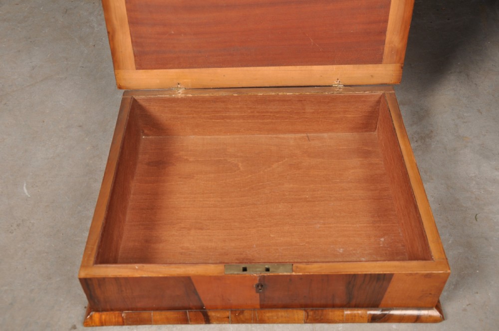 A rectangular 17th-century olive wood lace box featuring geometric oyster veneer marquetry on the lid and a brass keyhole escutcheon on the front. View VI
