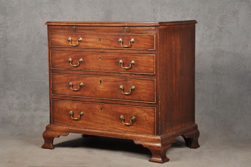 An 18th-century Georgian mahogany chest of drawers featuring four graduated drawers, brass swan-neck handles, a brushing slide, and bracket feet.