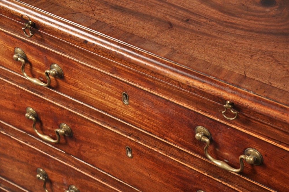 An 18th-century Georgian mahogany chest of drawers featuring four graduated drawers, brass swan-neck handles, a brushing slide, and bracket feet. View VI