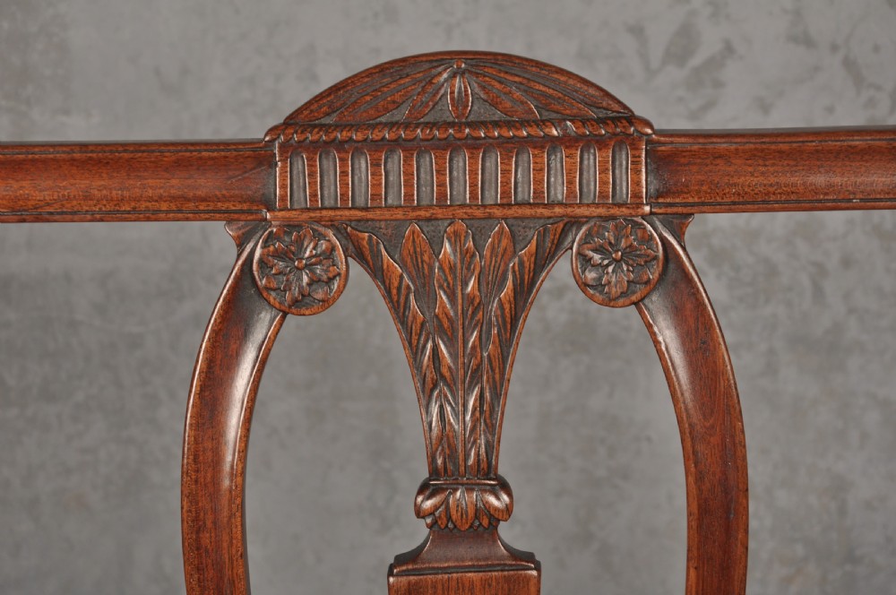 An 18th-century dark mahogany open armchair with a carved back splat, curved arms, square legs with stretchers, and pattern-upholstered seat. View II