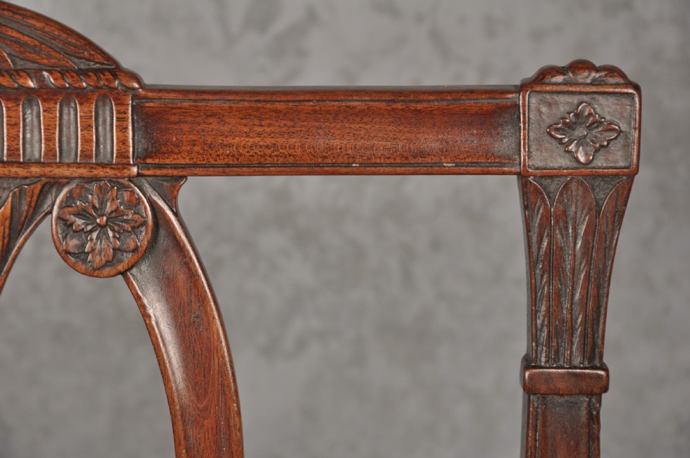 An 18th-century dark mahogany open armchair with a carved back splat, curved arms, square legs with stretchers, and pattern-upholstered seat. View III
